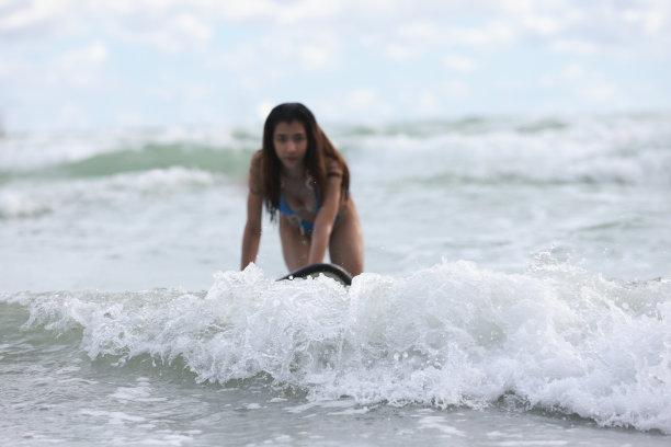 漂亮的女冲浪者在船上，溅水。冲浪者乘风破浪图片下载