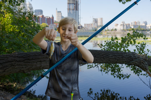 这个男孩夏天在河里钓鱼。图片下载