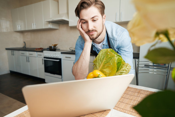 一个在网上寻找蔬菜沙拉食谱的人图片下载