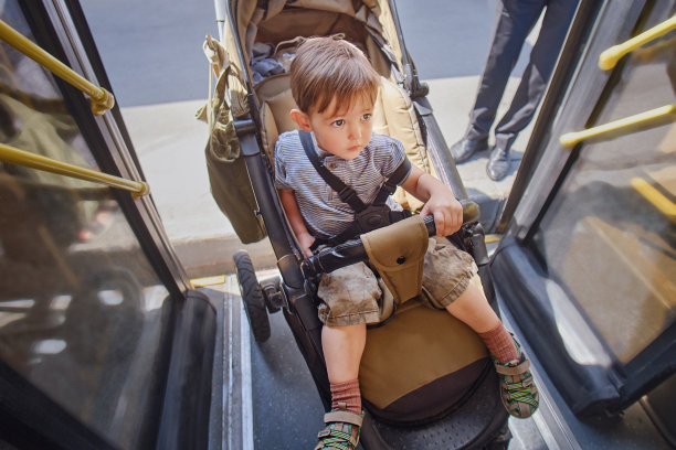 婴儿在公共汽车的车厢里，由一位成年母亲推着他们。两岁男童(2岁)图片下载