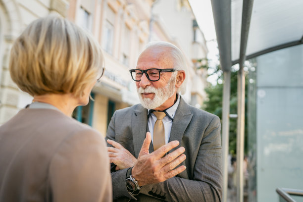 老男人和成熟女人在一个阳光明媚的日子里在城市相遇，聊起了老朋友图片下载