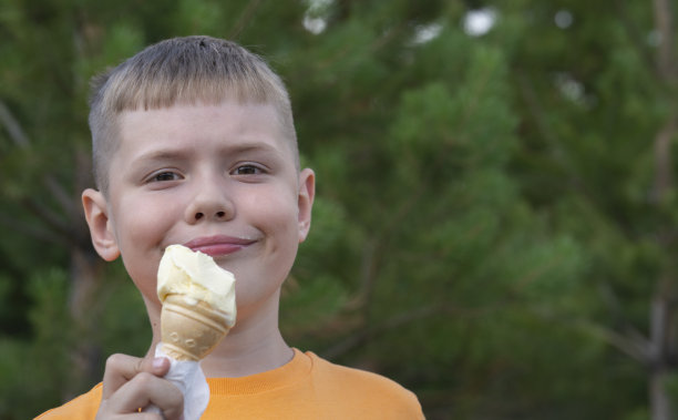 一个8岁的金发男孩用华夫杯吃冰淇淋。图片下载