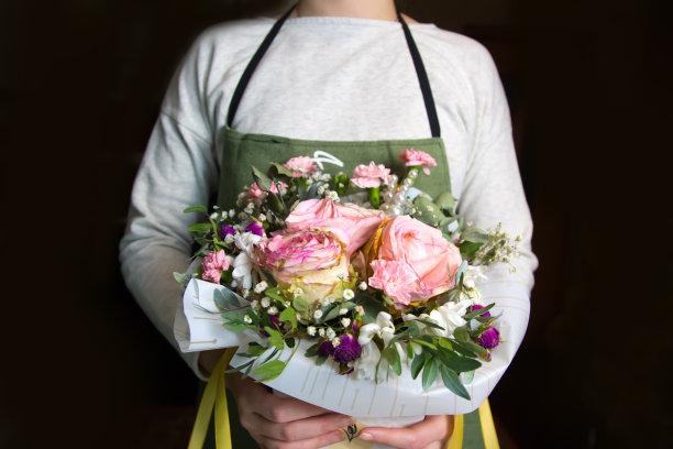 花卉设计。女人在包花束。整理一束鲜花图片下载