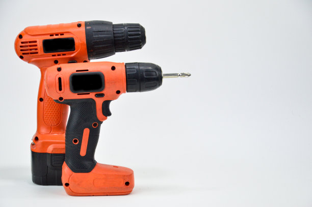 白色背景电动螺丝刀，橙色螺丝刀图片下载