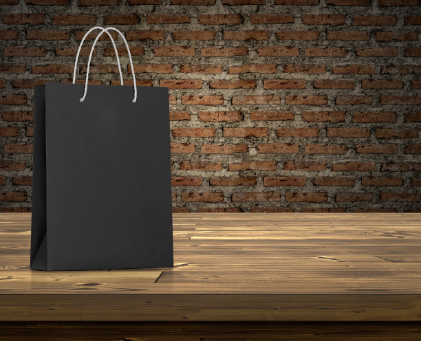 黑色砖墙里的广告室里，木桌上的空购物袋图片下载