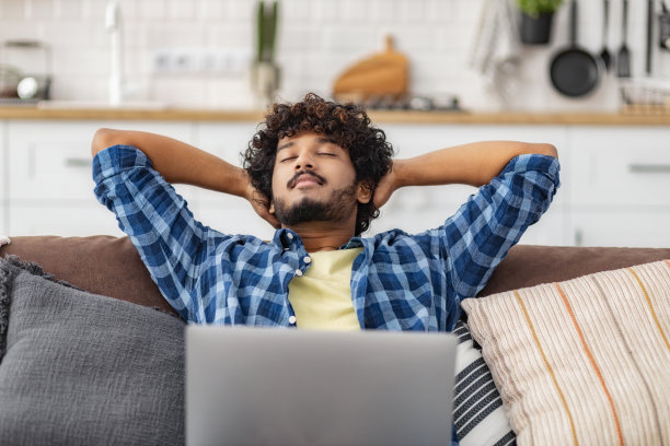 快乐的人自由职业者或学生放松在家里的沙发上图片下载