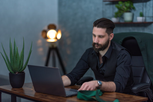 一个年轻的商人在办公室里一直坐到很晚图片下载