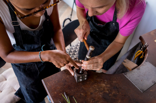 珠宝师老师和学生在车间制作珠宝图片下载