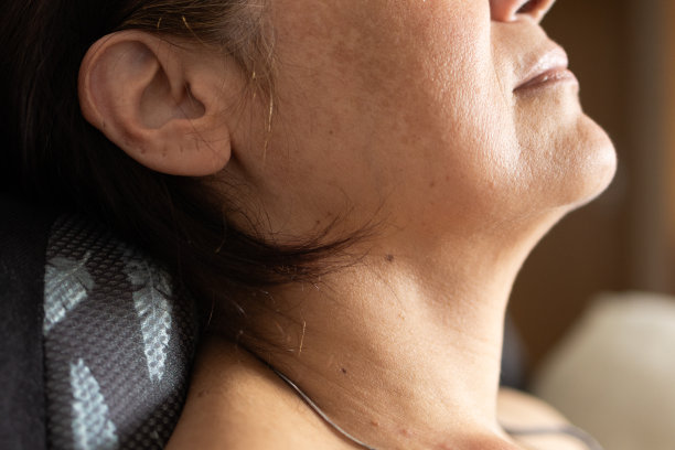 中年妇女使用颈椎按摩枕特写，居家放松身心图片下载