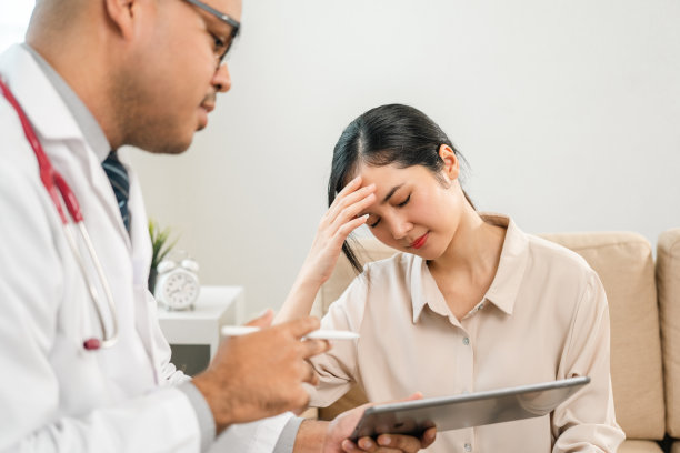 亚洲医生和病人讨论用数码平板电脑咨询。在医院里，病人与医生交谈，医生正在给妇女装药。医学和保健治疗的结果是临床图片下载