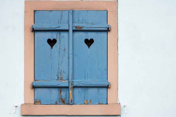 古老的蓝色窗户，紧闭的百叶窗，百叶窗上的心，蓝色的背景图片下载