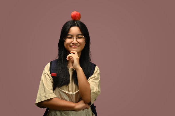 微笑的十几岁的亚洲女孩，苹果头孤立在粉红色的背景。健康，营养和节食图片下载