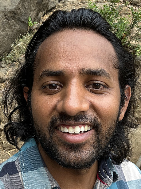 全画幅印度男性游客坐在相机前，在印度孟买象岛象窟前拍照，印度洞穴寺庙，自拍照片，历史岩石切割建筑，挖掘玄武岩，重点在前景图片下载