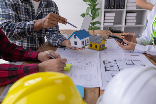 房地产经纪人和施工队领导一起工作。查看房屋设计和装修房屋计划。建设项目。抵押，租赁，买，卖，买，卖房子工程师团队开会。图片下载