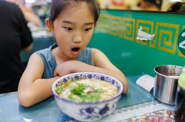 小女孩看着一大碗面条很惊讶图片下载