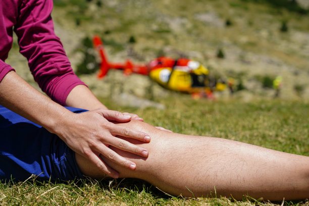 消防队员在紧急情况下乘坐山地救援直升机飞行。帮助一位膝盖疼痛的女士图片下载