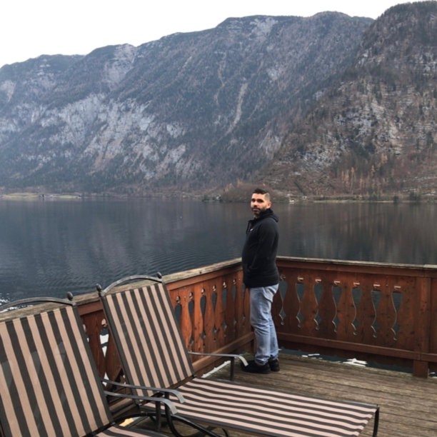 男子在酒店阳台上俯瞰水景图片下载