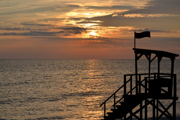 日出时海岸上的救生员哨所图片下载