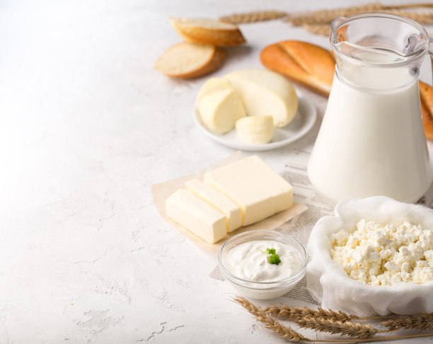 乳制品框架在浅灰色背景。把奶酪、牛奶、白干酪和酸奶平铺在浅色的桌面上，留出空间。图片下载