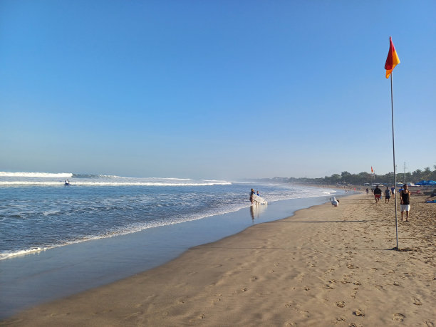 蓝天下沙滩上的红黄旗图片下载