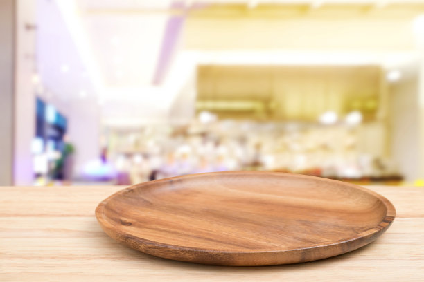 空木托盘透视木桌上的顶部模糊餐厅背景。可以用来模拟蒙太奇产品的展示或设计布局。图片下载