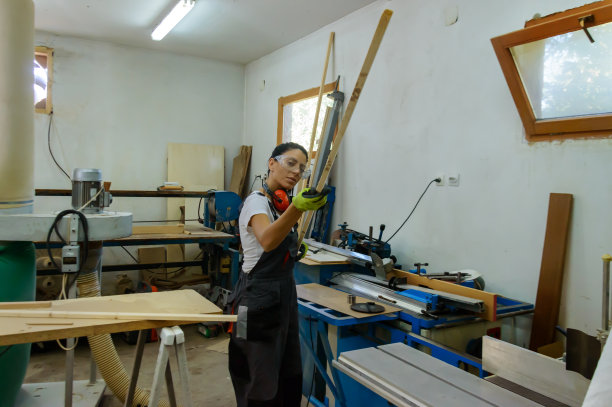 一位女木工正准备雕刻一块木板。图片下载