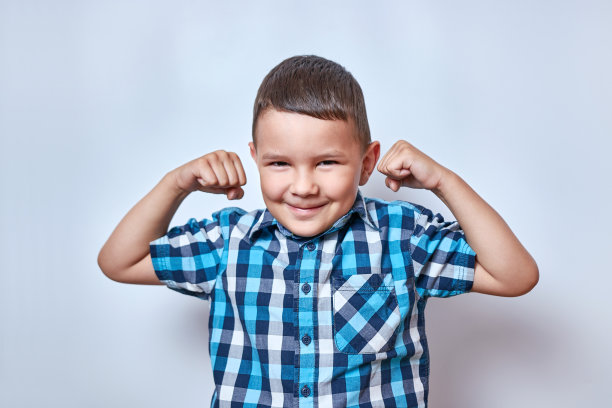 男孩举起双臂，绷紧了肱二头肌。运动和积极的娱乐活动。图片下载