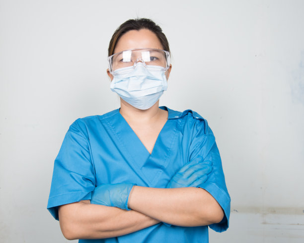 医生/护士穿戴制服防护设备，防止病原体感染。医务人员在医院的孤立背景。图片下载