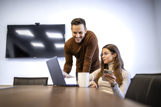 两个商业人士一起工作，并就项目相互提供建议。图片下载