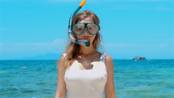 戴着潜水面罩站在海边的快乐女孩。图片下载