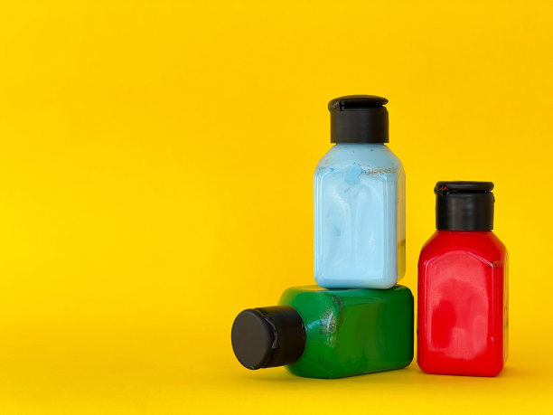 明亮的多色丙烯酸油漆在黄色背景的罐子。静物画图片下载