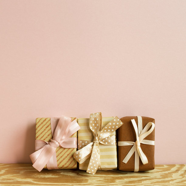 棕色的礼品盒放在木桌上。粉红色的背景墙。本空间图片下载