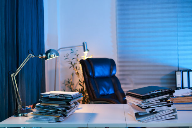 凌乱的办公桌和成堆的文件和文件，在家里的工作室的桌子上图片下载