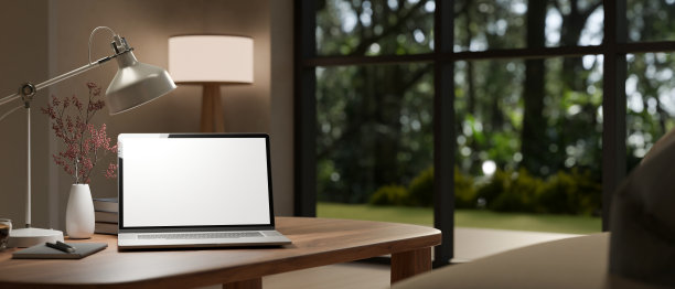 现代家庭工作室的工作空间，木桌上放着一台笔记本电脑模型。图片下载