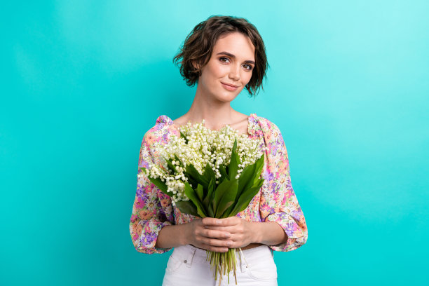 照片惊人的积极的女士手捧花束鲜花隔离在明亮的海蓝宝石色背景图片下载