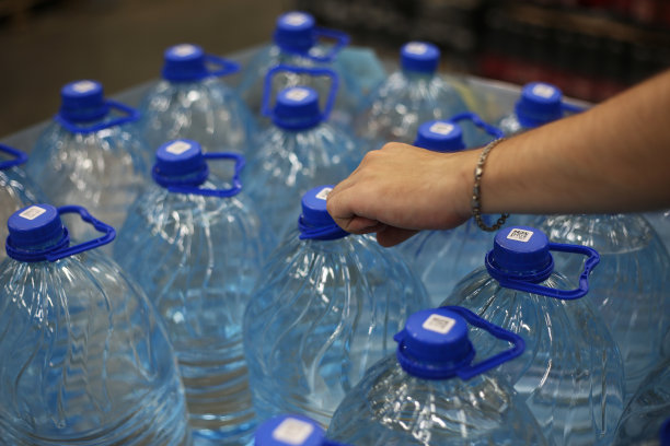 男人的手从商店里拿出一瓶五升的水图片下载