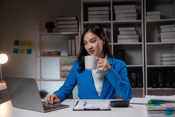 亚洲女商人在晚上工作时喝咖啡图片下载