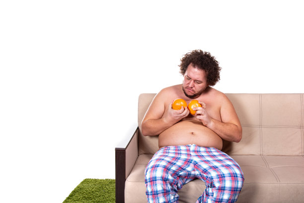 滑稽的胖子在家看电视。图片下载