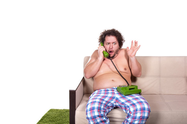 滑稽的胖子在家看电视。图片下载