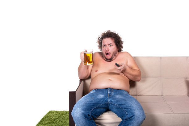 滑稽的胖子在家看电视。图片下载