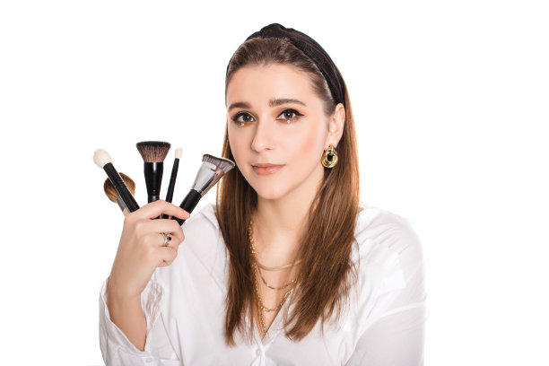 年轻美丽的专业化妆师与化妆刷隔离在白色背景。图片下载