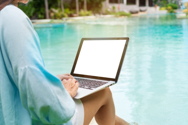自由职业者使用笔记本电脑在游泳池附近远程工作。年轻的亚洲旅行者在暑假期间在电脑上工作。工作在任何地方，技术和生活方式的概念，复制空间图片下载