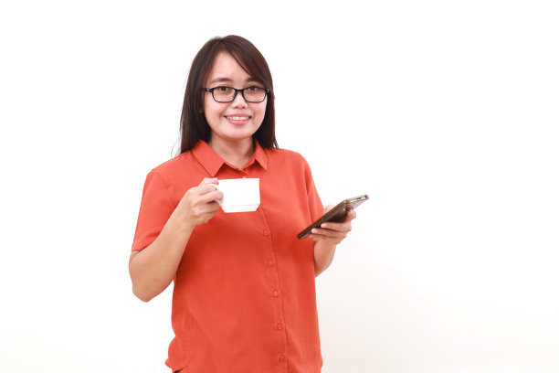站着拿着手机和一杯咖啡的快乐的年轻亚洲女性肖像图片下载
