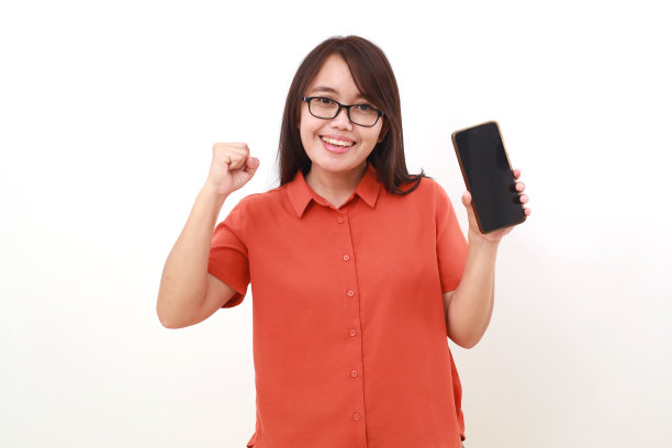 快乐的年轻亚洲女子展示空白的模拟手机屏幕，同时展示成功的拳头图片下载