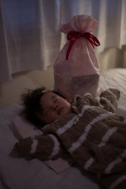 熟睡的孩子拿着圣诞礼物图片下载