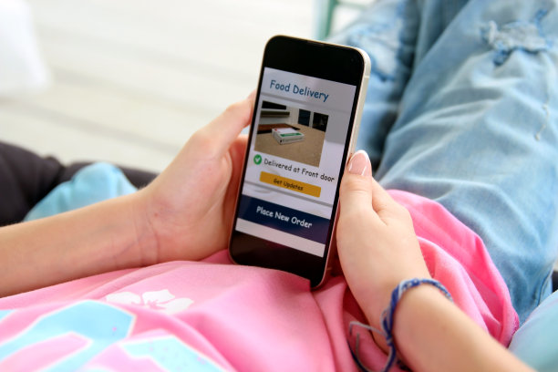 女孩正在检查分娩情况。使用手机应用程序在线订购披萨。图片下载