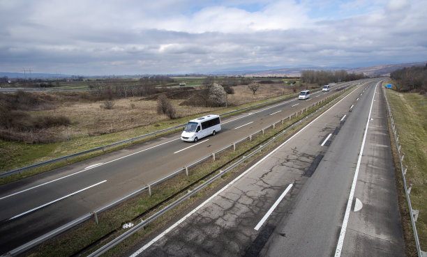 小型现代舒适的旅游巴士行驶在高速公路上。旅游和巴士旅游的概念。图片下载