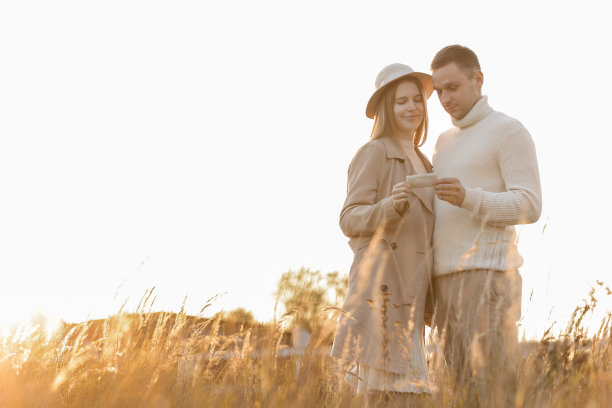 一名未被认出的孕妇和她的丈夫在户外大自然的阳光下拿着未出生的孩子的超声波扫描照片。快乐的母亲和为人父母的概念图片下载