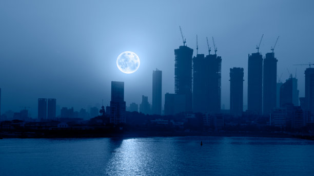 孟买是印度的金融和娱乐之都——建筑起重机和摩天大楼与夜晚的满月图片下载