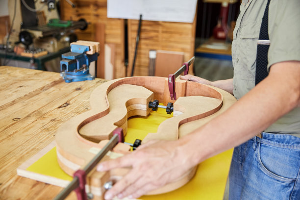 不知名的制琴师在他的工匠工作室里制作一把原声吉他图片下载